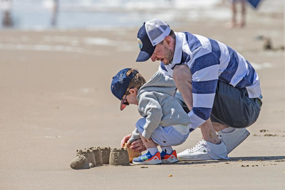 A father and his son build sand castles on day 1 of the Memorial Day Weekend at Rehoboth Beach on Saturday, May 27, 2023.