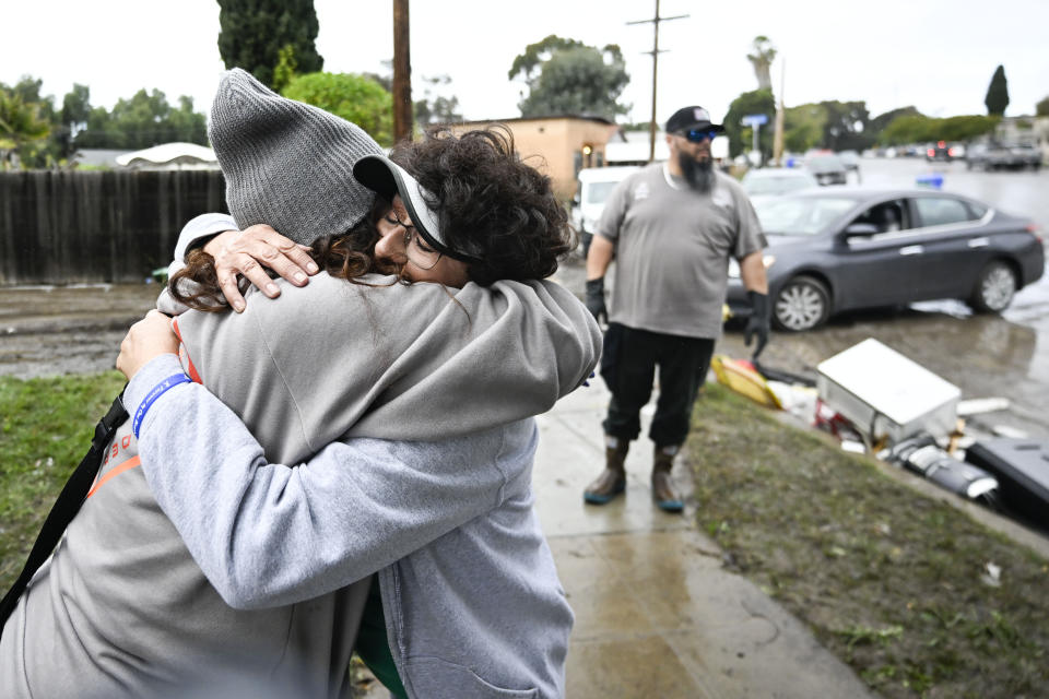 Homeowner Deanna Samayoa, left, hugs her neighbor Anita Torones in front of her home damaged by flooding Tuesday, Jan. 23, 2024, in San Diego. Deanna Samayoa's home was damaged when flood waters rushed though her home on Monday, Jan. 23, 2024. California Gov. Gavin Newsom declared a state of emergency for San Diego County and Ventura County, which was also hit by heavy rains that caused flooding there in late December, stating that “I find that local authority is inadequate to cope with the magnitude of the damage caused by these winter storms.” (AP Photo/Denis Poroy)