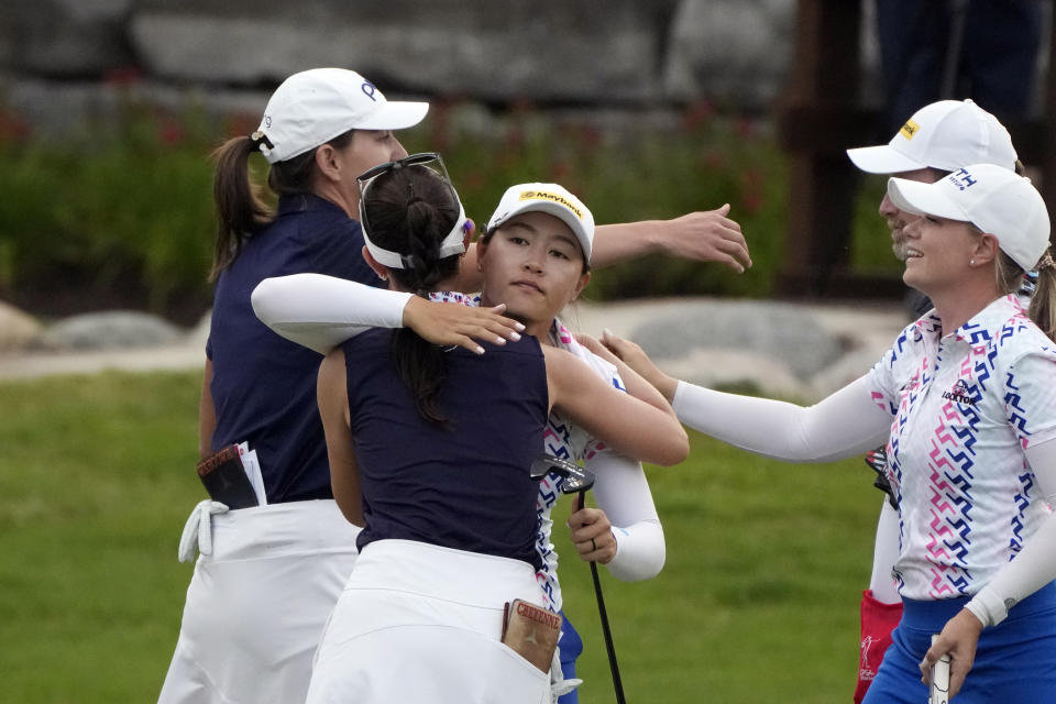 Kelly Tan, center hugs Cheyenne Knight as Matilda Castren of Finland, right, prepares to hug Elizabeth Szokol on the 18th green during the final round of the Dow Great Lakes Bay Invitational golf tournament at Midland Country Club, Saturday, July 22, 2023, in Midland, Mich. (AP Photo/Carlos Osorio)