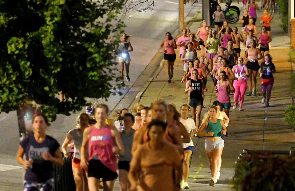 Runners head down the sidewalk past Fountain Square on Georgia Avenue during "Finish Eliza's Run" on Friday, Sept. 9, 2022 in Chattanooga, Tenn. The approximately four mile run was to memorialize, Eliza Fletcher, the Memphis runner, and mother of two, who was murdered during her early morning run. (Robin Rudd /Chattanooga Times Free Press via AP)