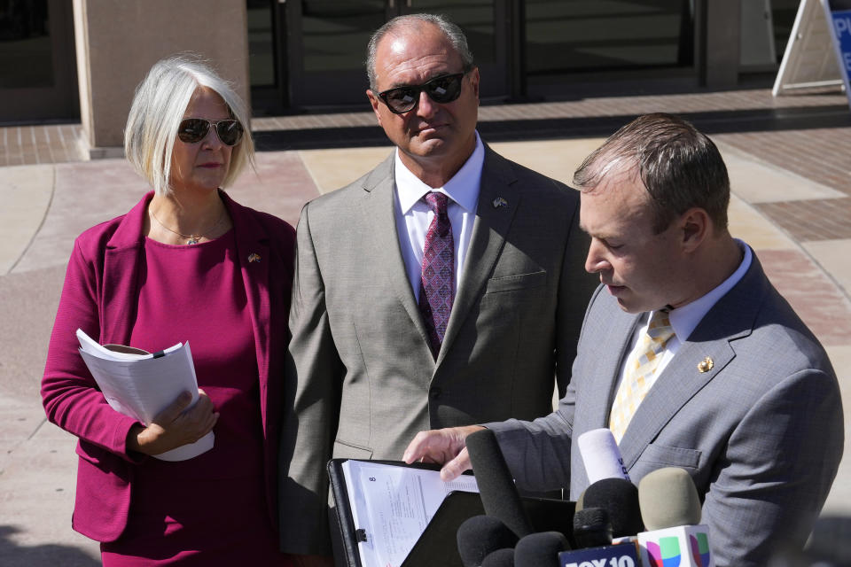 Attorney Brad Miller, right, speaks with reporters as former Arizona Republican Party chair Kelli Ward, left, and husband Michael Ward, center, stand in front of Maricopa County Superior Court after their arraignment as they joined at least 10 other people who were also arraigned for conspiracy, forgery and fraud charges role in an effort to overturn Donald Trump's 2020 election loss in Arizona to Joe Biden Tuesday, May 21, 2024, in Phoenix. (AP Photo/Ross D. Franklin)