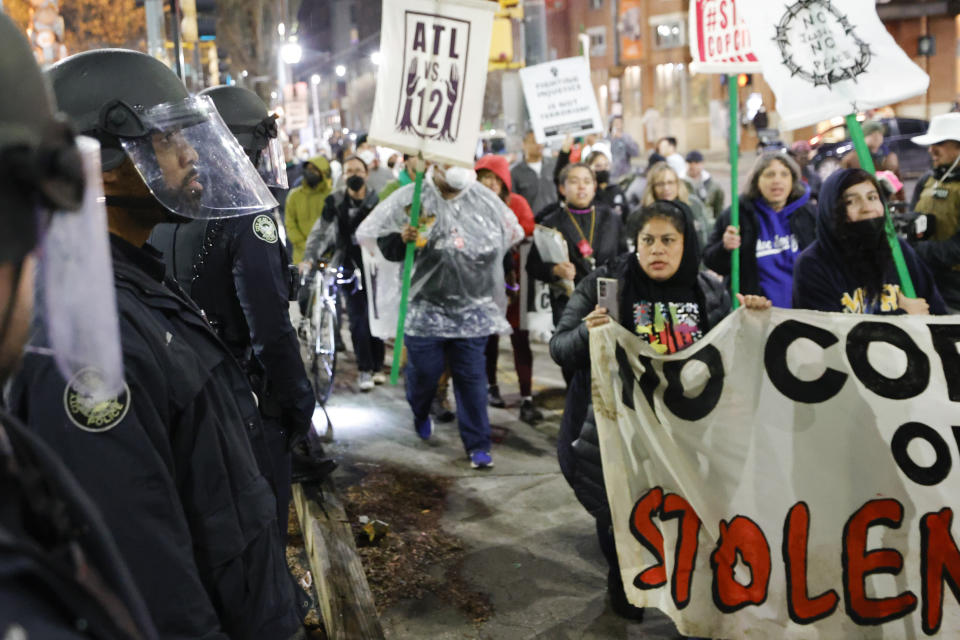 FILE - Demonstrators march near Atlanta police during a protest over plans to build a new police training center, Thursday, March 9, 2023, in Atlanta. A prosecutor on Friday, Oct. 6, says no charges will be sought against Georgia state troopers who shot and killed an activist at the site of a planned police and firefighter training center near Atlanta. (AP Photo/Alex Slitz, File)