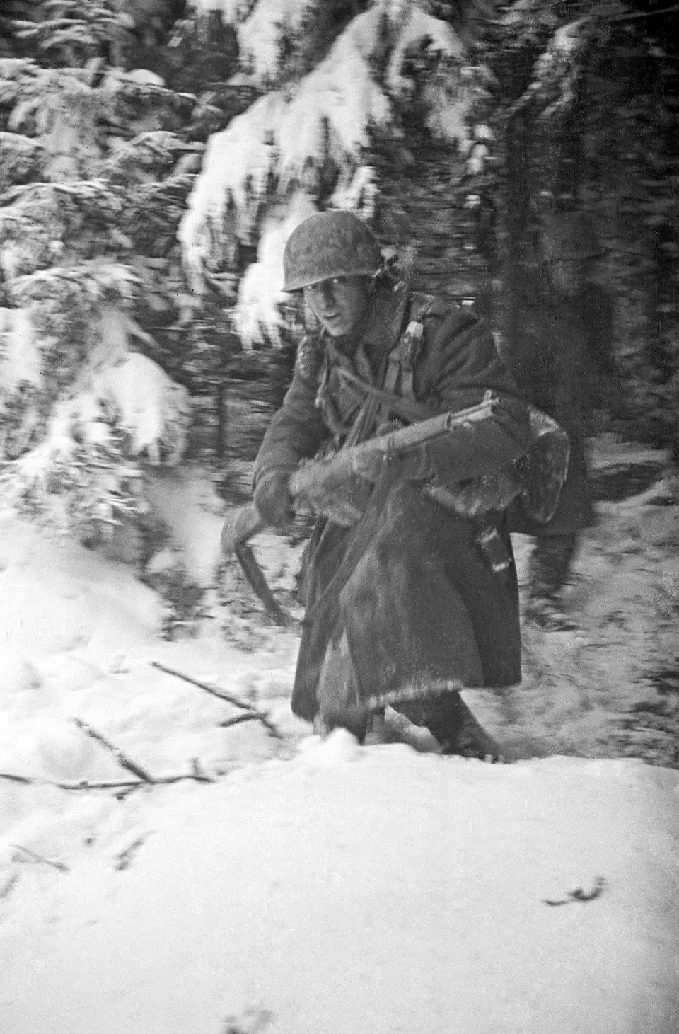 In this 1944 photo titled "Hell In Hurtgen" by photographer Tony Vaccaro, shows an American soldier in Germany's Hurtgen Forest. Vaccaro, 97, was thrown into WWII with the 83rd Infantry division which fought, like Charles Shay, in Normandy, and then came to Schmetz's doorstep for the Battle of the Bulge. On top of his military gear, he also carried a camera, and became a fashion and celebrity photographer after the war. COVID-19 caught up with him last month. Like everything bad life threw at him, he shook it off, attributing his survival to plain "fortune." (Photo courtesy Tony Vaccaro via AP)
