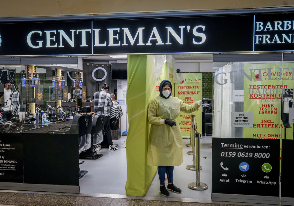 A medical worker stands in the door of a barber shop that was partially changed into a test center in Frankfurt, Germany, Monday, Nov. 15, 2021. The numbers of Corona infections have been rising again in Germany. (AP Photo/Michael Probst)