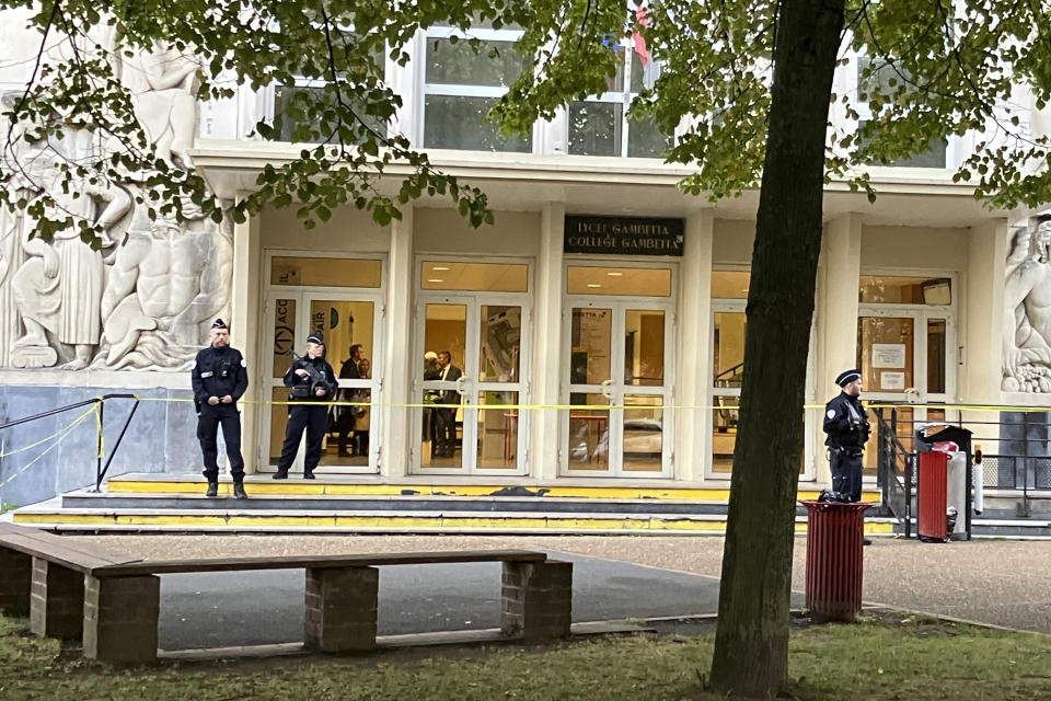 Police officers stand guard outside the high school where a man stabbed a teacher, Saturday Oct.14, 2023 in Arras, northern France. A man of Chechen origin who was under surveillance by French security services over suspected Islamic radicalization stabbed a teacher to death at his former high school and wounded three other people Friday in Arras. (AP Photo/Jeffrey Schaeffer)