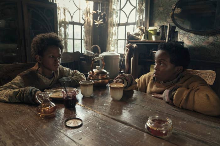 Percy Daggs IV and Anthony B. Jenkins sitting at a table with dishes on it in "Never Let Go"