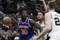 New York Knicks' Julius Randle (30) drives against San Antonio Spurs' Jakob Poeltl, right, and Bryn Forbes during the first half of an NBA basketball game, Tuesday, Dec. 7, 2021, in San Antonio. (AP Photo/Darren Abate)