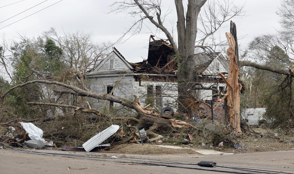 A house is damaged and trees snapped in Selma, Ala., Friday, Jan. 13, 2023, after a tornado passed through the area the day before. Rescuers raced Friday to find survivors in the aftermath of a tornado-spawning storm system that barreled across parts of Georgia and Alabama. (AP Photo/Stew Milne)