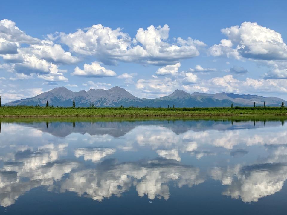 The Jade Mountains are reflected in the Kobuk River.