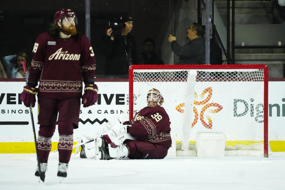 Arizona Coyotes goaltender Connor Ingram (39) slides along the ice after giving up a goal to Colorado Avalanche right wing Mikko Rantanen as Coyotes center Liam O'Brien, left, pauses on the ice during the second period of an NHL hockey game, Sunday, March 26, 2023, in Tempe, Ariz. (AP Photo/Ross D. Franklin)