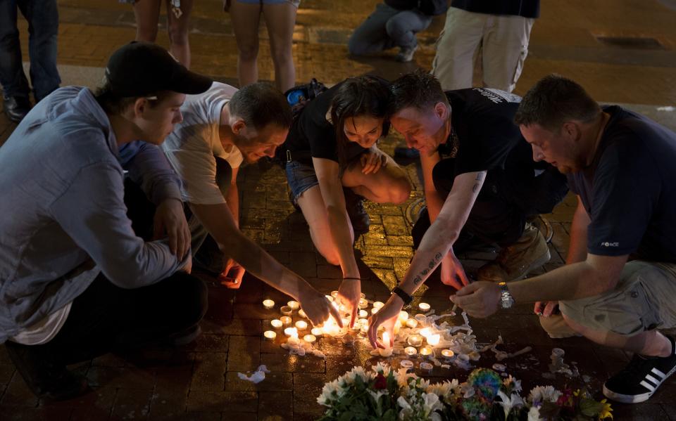 <p>People place candles as they gather during a vigil in Charlottesville, Virginia, USA, 12 August 2017. According to media reports at least one person was killed and 19 injured after a car hit a crowd of people counter-protesting the ‘Unite the Right’ rally which was scheduled to take place in Charlottesville on 12 August. At least 15 others were injured in clashes during protests. (Tasos Katopodis/EPA/REX/Shutterstock) </p>