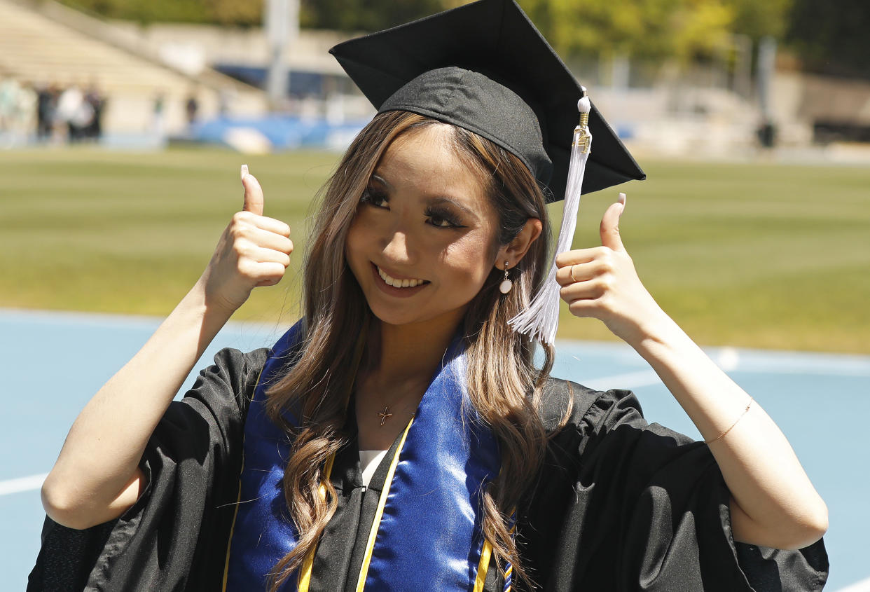 Graduate Maddie Park gives a thumbs up to her parents Richard and Stephanie Park as graduating UCLA students walk the stage in Drake Stadium on UCLA on Thursday, June 10, 2021 in Los Angeles, CA. (Al Seib / Los Angeles Times via Getty Images).