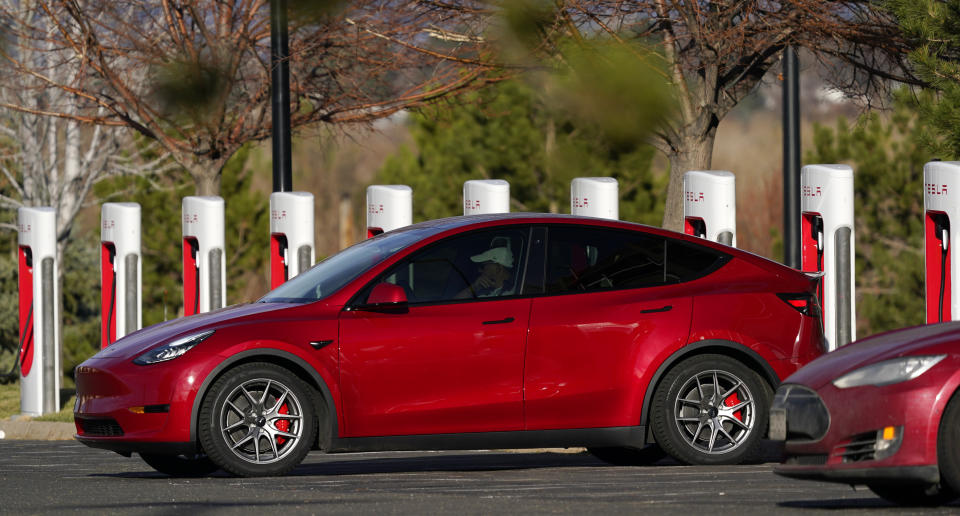 A motorist charges a 2020 Model Y at a Tesla supercharging station located in the parking lot of Colorado Mills outlet mall Wednesday, Nov. 17, 2020, in Golden, Colo. (AP Photo/David Zalubowski)