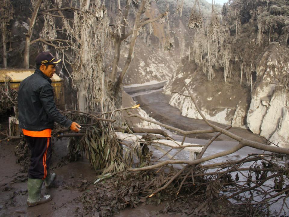 An Indonesian rescue officer stands near a broken bridge that was hit by the eruption of Mount Semeru in Candipuro village, Lumajang, Indonesia December 5, 2021,