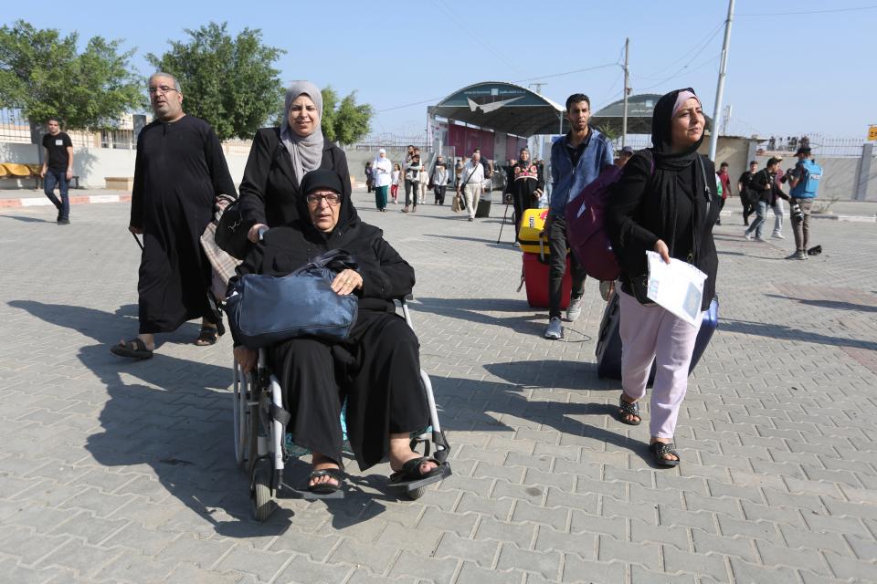 Palestinians cross to the Egyptian side of the border crossing with the Gaza Strip Wednesday, Nov. 1, 2023.
