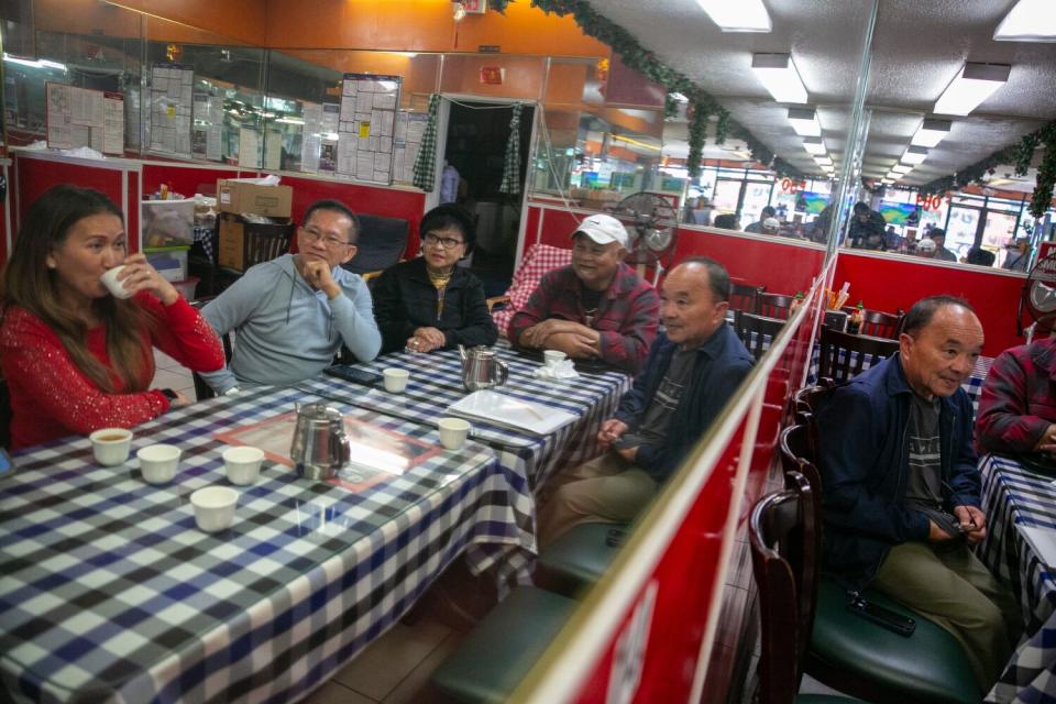 A group of men and women gather at a restaurant in Long Beach.