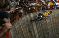 A motorcyclist performs a stunt on the wooden walls of the "Well of Death" at a fair near the historic Red Fort in Delhi September 22, 2009. REUTERS/Parth Sanyal