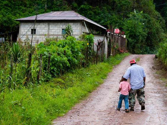 Rodrigo Carrillo and his five-year-old son walk up the dirt road in Hoja Blanca (Sarah L Voisin/Washington Post)