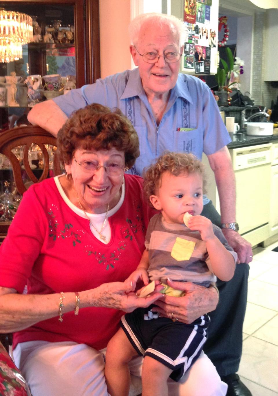 Anna and Spencer Meckstroth pose with Haydon, one of their great-grandchildren, in their collectible-filled living room.
