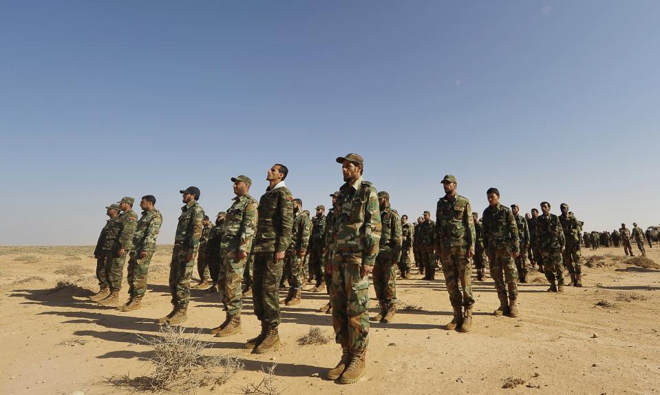 Trainee soldiers from the Libyan army stand at attention during their graduation exam in Geminis