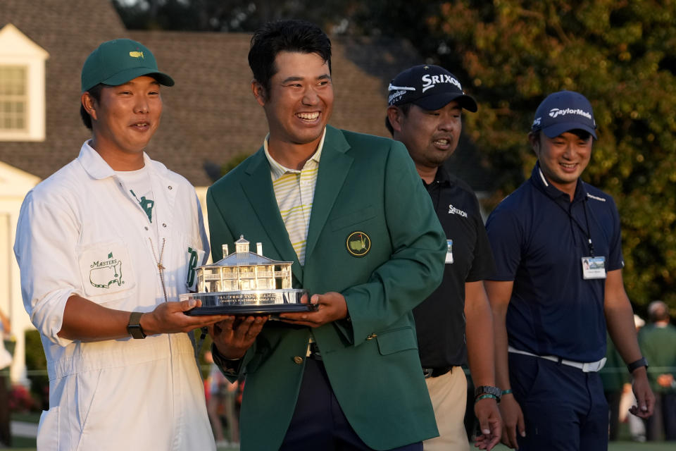 Hideki Matsuyama, of Japan, holds his trophy with his caddie Shota Hayafuji after winning the Masters golf tournament on Sunday, April 11, 2021, in Augusta, Ga. (AP Photo/David J. Phillip)