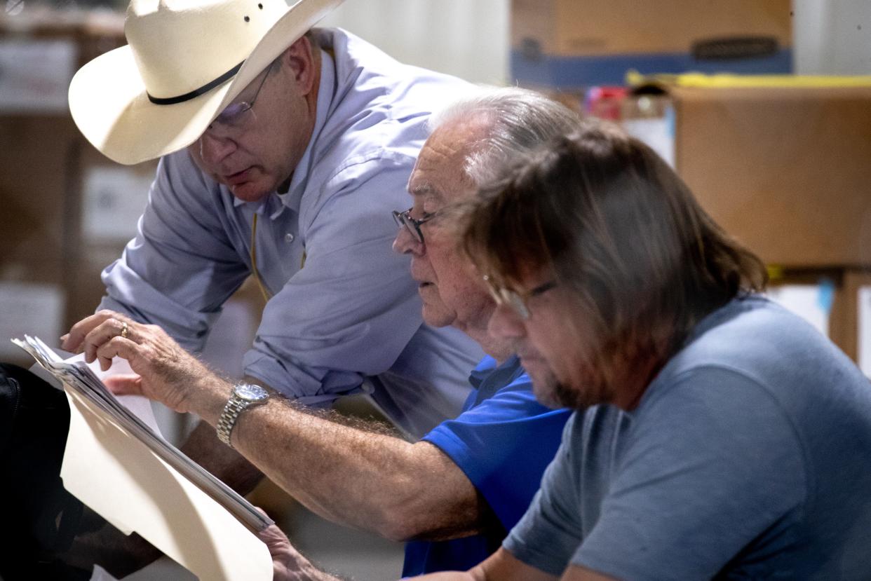 Audit spokesperson Randy Pullen (center) looks through paperwork, July 19, 2021, in the Wesley Bolin Building at the Arizona State Fairgrounds, Phoenix.