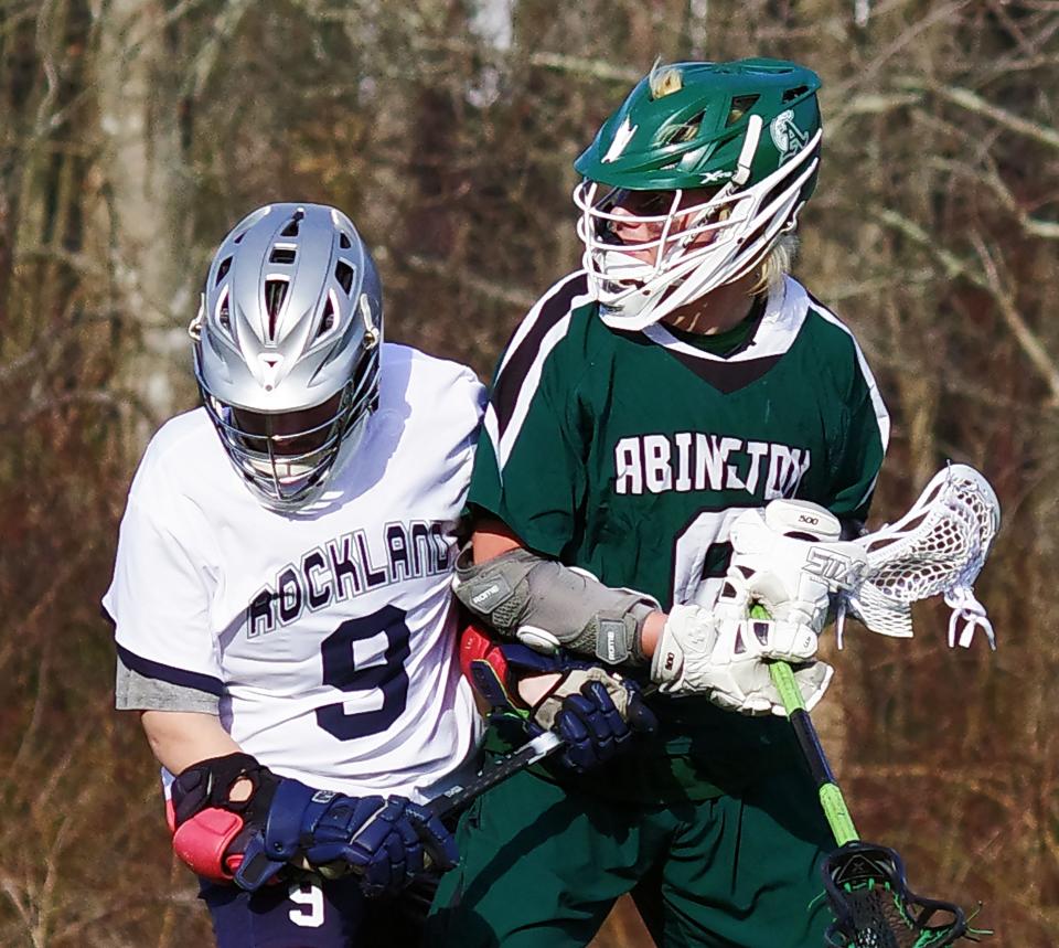 Rockland's Bryce Marrero and Abington's Hunter Grafton fight for control of the ball in the 2nd half of the lacrosse game on Tuesday, April 4, 2023.