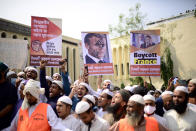 Supporters of Islami Andolan Bangladesh, an Islamist political party, hold posters of French President Emmanuel Macron as they protest against the publishing of caricatures of the Prophet Muhammad they deem blasphemous, in Dhaka, Bangladesh, Tuesday, Oct. 27, 2020. Muslims in the Middle East and beyond on Monday called for boycotts of French products and for protests over the caricatures, but Macron has vowed his country will not back down from its secular ideals and defense of free speech. Poster reads "Muslims will not tolerate insults to the prophet. Muslims of the world unite and fight." (AP Photo/Mahmud Hossain Opu)