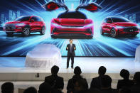 Wang Chuanfu, chairman and president of BYD Auto, the biggest global electric brand by sales volume, prepares to show the latest cars during the Auto Shanghai 2019 show in Shanghai Tuesday, April 16, 2019. Automakers are showcasing electric SUVs and sedans with more driving range and luxury features at the Shanghai auto show, trying to appeal to Chinese buyers in their biggest market as Beijing slashes subsidies that have propelled demand. (AP Photo/Ng Han Guan)