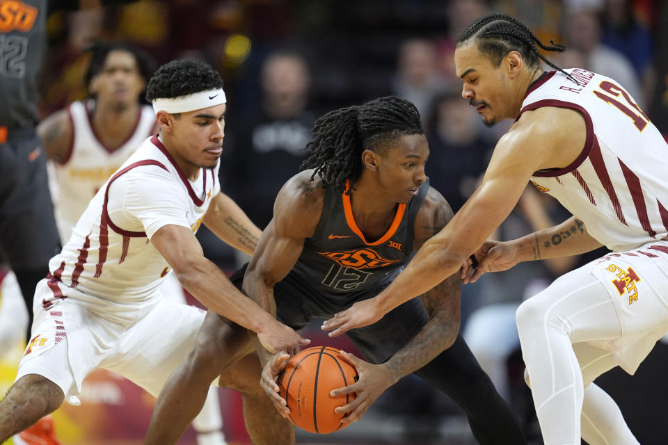 Iowa State guard Tamin Lipsey, left, and forward Robert Jones, right, try to steal the ball from Oklahoma State guard Javon Small, center, during the second half of an NCAA college basketball game, Saturday, Jan. 13, 2024, in Ames, Iowa. Iowa State won 66-42. (AP Photo/Charlie Neibergall)