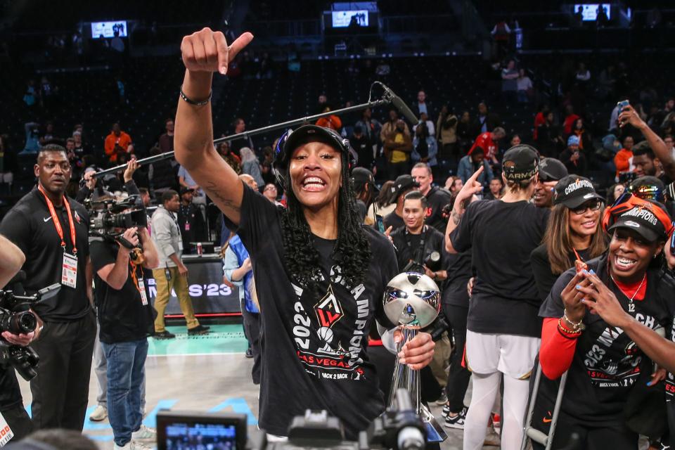 A'ja Wilson celebrates with the MVP trophy after the Aces won the WNBA championship.