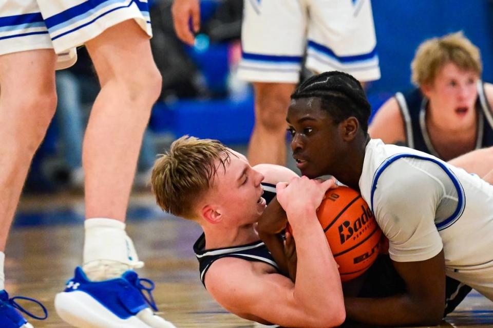 Curtis guard Zoom Diallo (5) and Olympia guard Parker Gerrits (22) stop after fighting on the floor for a loose ball during the fourth quarter of a 4A South Puget Sound League game on Friday, Jan. 21, 2022, at Curtis High School in University Place, Wash.