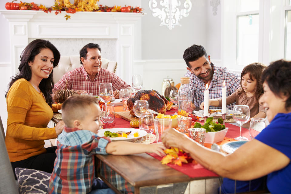 Family With Grandparents Enjoying Thanksgiving Meal At Table