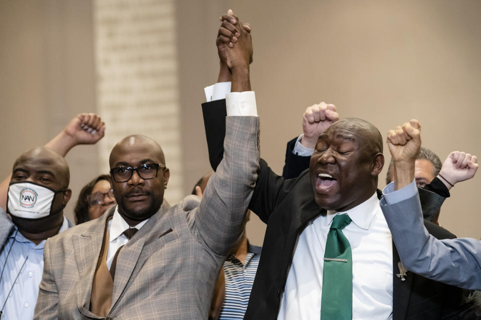 Philonise Floyd, brother of George Floyd, left, and attorney Ben Crump raise their hands in triumph during a news conference after the murder conviction against former Minneapolis police Officer Derek Chauvin in the killing of George Floyd, Tuesday, April 20, 2021, in Minneapolis. (AP Photo/John Minchillo)