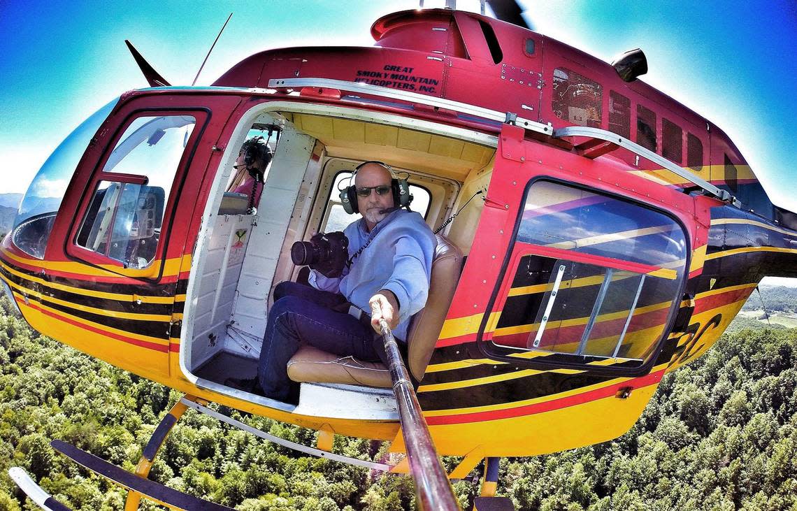 News & Observer photojournalist Chuck Liddy uses a camera on a pole to photograph himself working from the ABC11 helicopter.