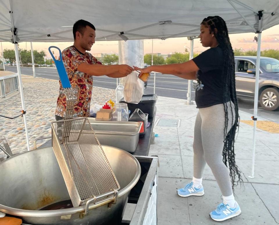Santiago Juarez, left, serves churros to a first-time customer on Monday, August 14, 2023 in Fresno, California. Fresno County has launched a new education awareness campaign to bring unlicensed mobile food businesses into compliance.