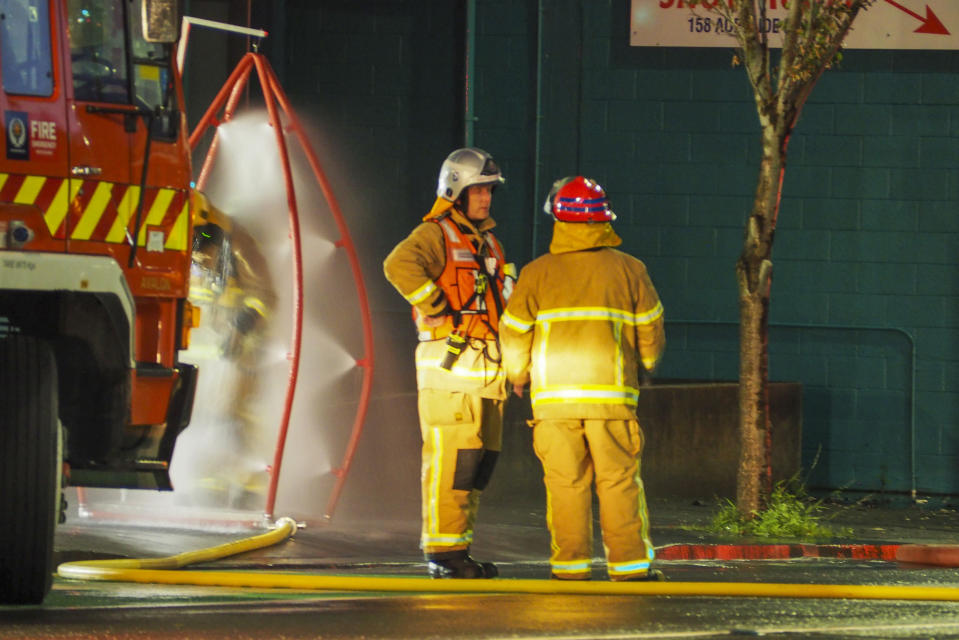 Firefighters stand outside a fire at a hostel in central Wellington, New Zealand, early Tuesday, May 16, 2023. Several people were killed after a fire broke out overnight at the four-story building. (Nick James/NZ Herald via AP)