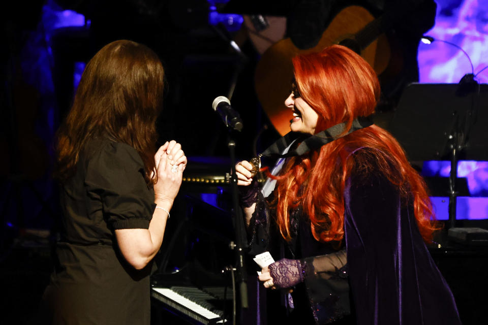Wynonna Judd, right, shows her medallion to sister Ashley Judd during the Medallion Ceremony at the Country Music Hall of Fame on Sunday, May 1, 2022, in Nashville, Tenn. (Photo by Wade Payne/Invision/AP)