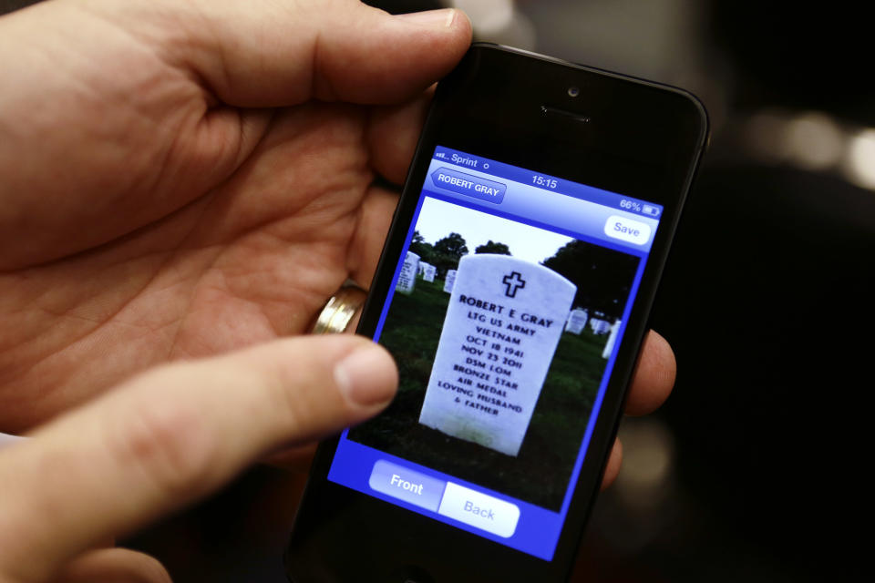 Army Col. John Schrader demonstrates the ANC Explorer application for Arlington National Cemetery, on his phone, after a news conference in Washington, Monday, Oct. 22, 2012. Arlington National Cemetery plans to make available to the public the detailed geospatial database it has developed over several years while overhauling its records and responding to reports of misidentified remains. The database will be available over the Internet and through a mobile phone app that visitors to the cemetery can take with them to find a specific gave anywhere in the cemetery. (AP Photo/Jacquelyn Martin)