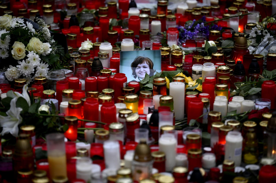 A view of floral tributes and candles outside the headquarters of Charles University in downtown Prague, Czech Republic, Saturday, Dec. 23, 2023. A lone gunman opened fire at a university on Thursday, killing over 12 people and injuring dozens. (AP Photo/Denes Erdos)