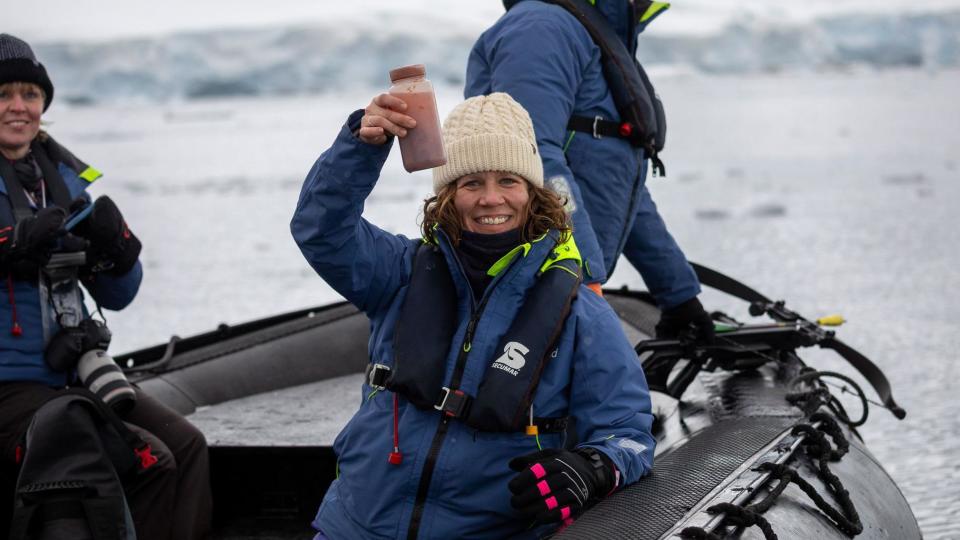 Scientist Dr Sarah Kienle holds a sample jar of whale poo