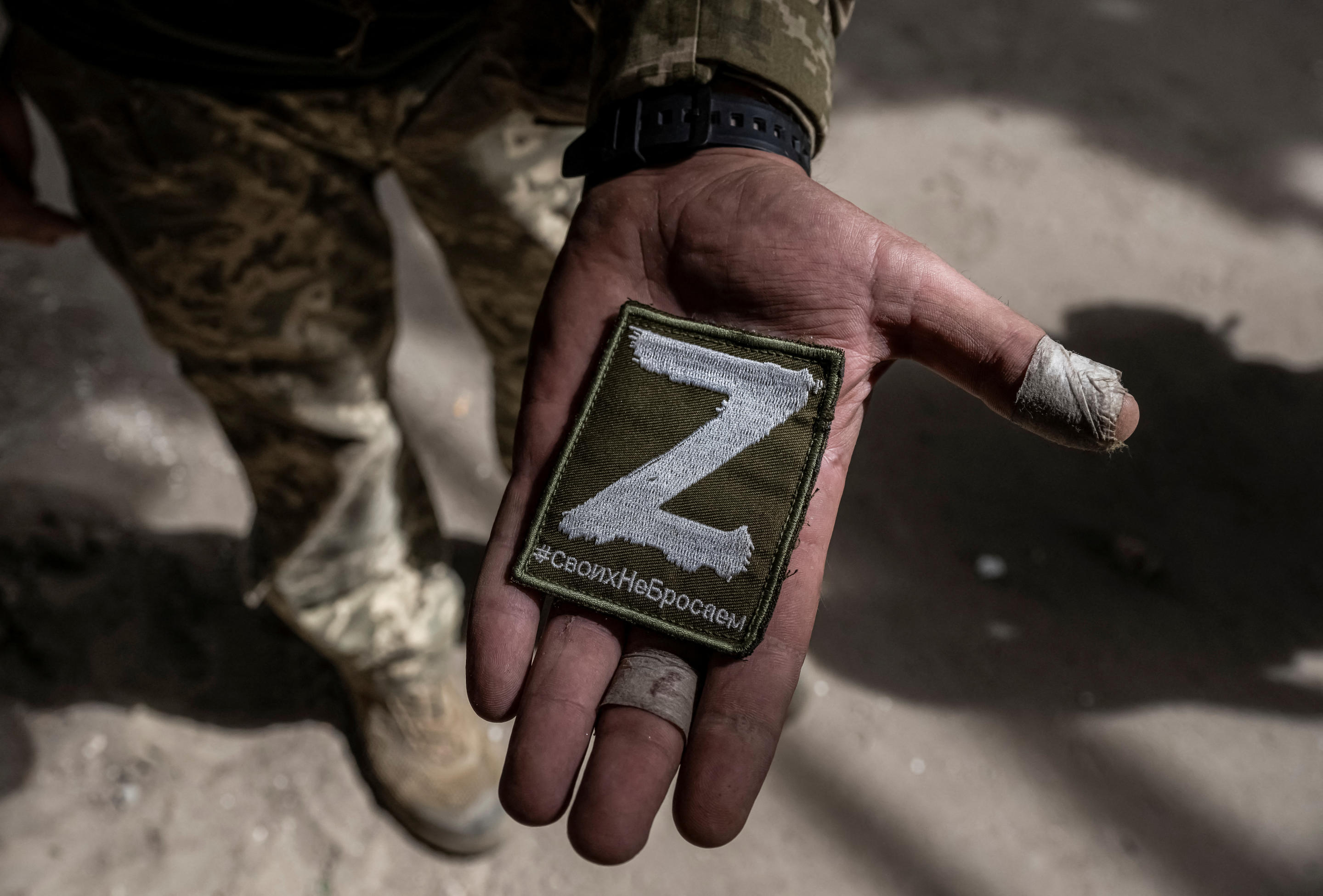 A Ukrainian serviceman shows a Russian military patch.