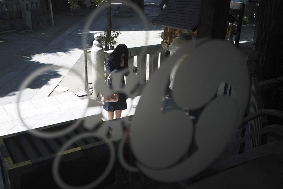 In this May 8, 2020, photo, a visitor prays at Onoterusaki Shrine in downtown Tokyo. The shrine offered a 10-day trial of "online shrine" visit program allowing its visitors to join rituals from their homes. The shrine also accepted from worshipers their prayer messages, which were printed on a virtual wooden tablet each and offered to the Shinto gods to keep away evil spirits and the epidemic. (AP Photo/Eugene Hoshiko)