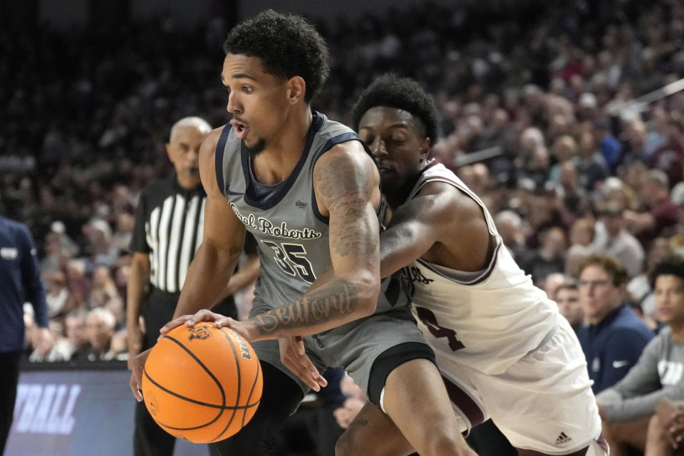 Texas A&M guard Wade Taylor IV (4) tries to knock the ball away from Oral Roberts guard Jailen Bedford (35) who drives the baseline during the second half of an NCAA college basketball game Friday, Nov. 17, 2023, in College Station, Texas. (AP Photo/Sam Craft)