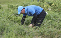 Northern Ireland's Rory McIlroy looks for his ball in the long rough on the 1st hole during the first round of the British Open Golf Championships at Royal Portrush in Northern Ireland, Thursday, July 18, 2019.(AP Photo/Peter Morrison)