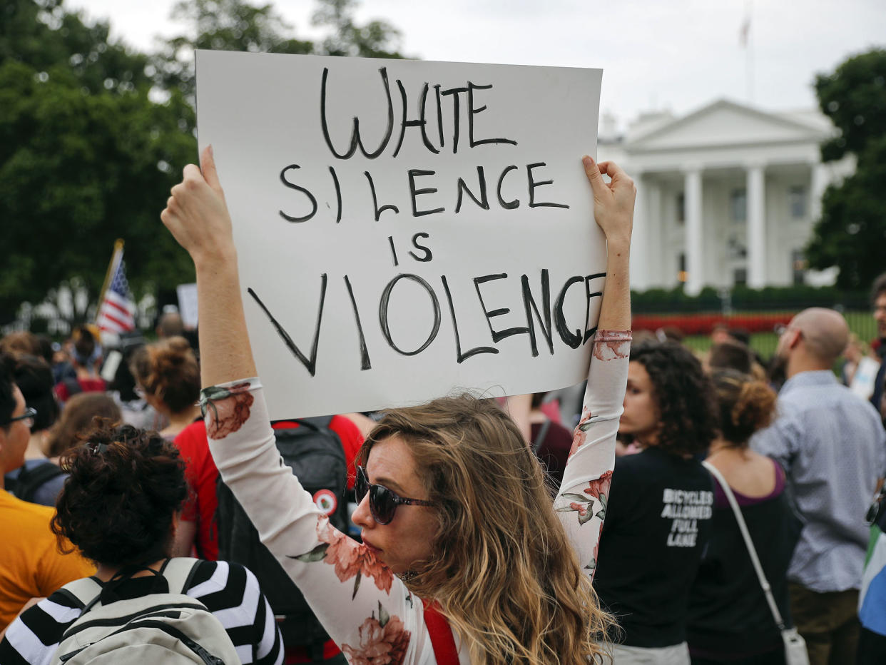 A protester holds up a sign outside the White House in response to the Charlottesville protests: AP