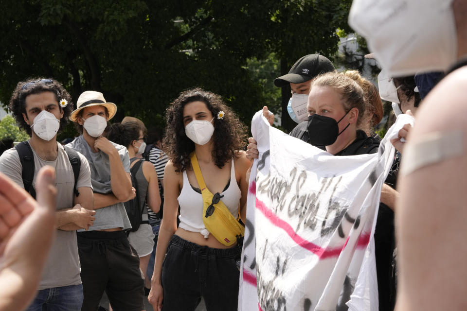 Zeynep, center, a Gorillas rider from Turkey who declined to give her last name for fear of facing repercussions from the company, blocks with other workers the entrance of a depot for German startup Gorillas, a grocery delivery company, to protest the firing of a colleague in Berlin, Germany, Thursday, June 10, 2021. The company Gorillas operates in dozens of cities across Germany, France, Italy, the Netherlands and Britain, and has already set its sights on New York. (AP Photo/Markus Schreiber)