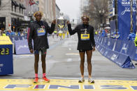 Evans Chebet and Hellen Obiri, both of Kenya, hold the trophy at the finish line after winning the 127th Boston Marathon, Monday, April 17, 2023, in Boston. (AP Photo/Winslow Townson)
