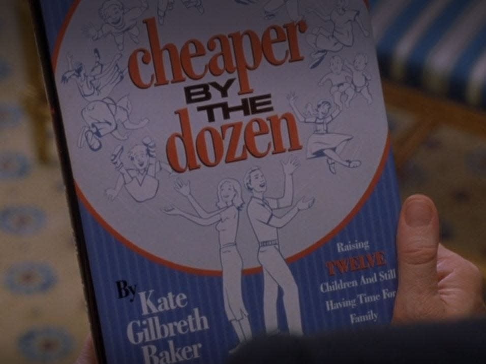 kate holding cheaper by the dozen book in cheaper by the dozen