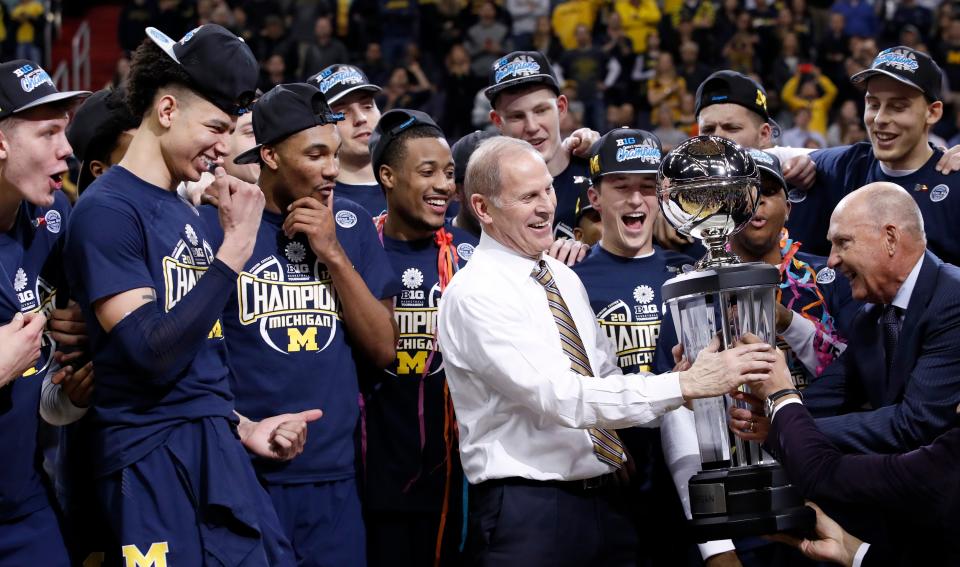 Michigan basketball coach John Beilein accepts the trophy from Big Ten commissioner Jim Delany, right, after defeating Wisconsin for the conference tournament title Sunday, March 12, 2017, in Washington.